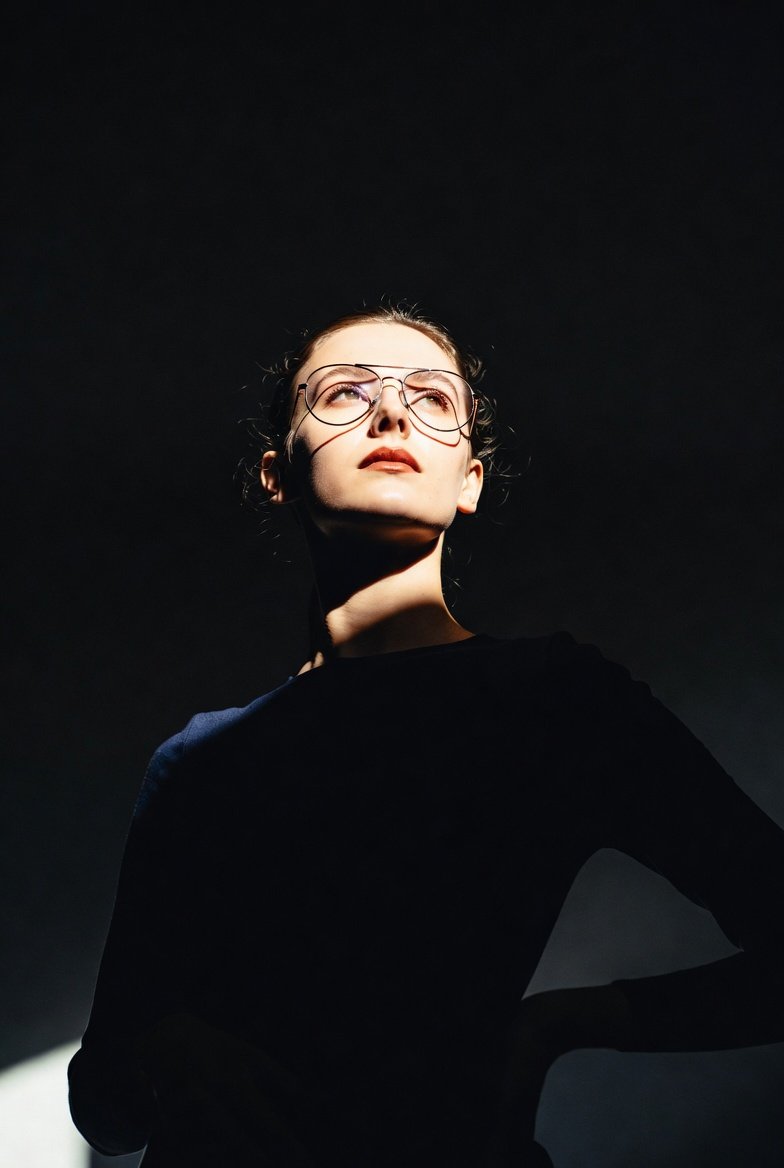 Dramatic, low-angle portrait of a woman standing in a dark