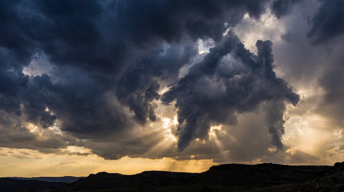 Epic Sunset Sky: Sun Rays Piercing Dark Storm Clouds