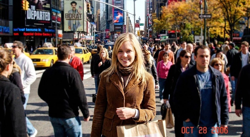 Generate a photorealistic image of Time Square on a saturday in Fall 2006, it's